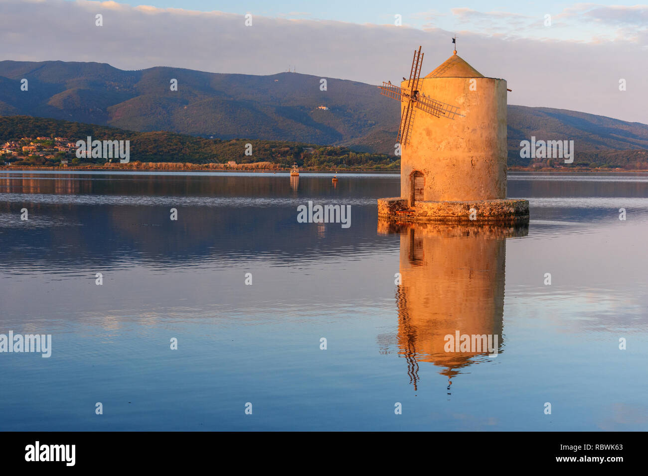 Old Spanish windmill in lagoon Orbetello on peninsula Argentario at sunise. Tuscany. Italy Stock Photo