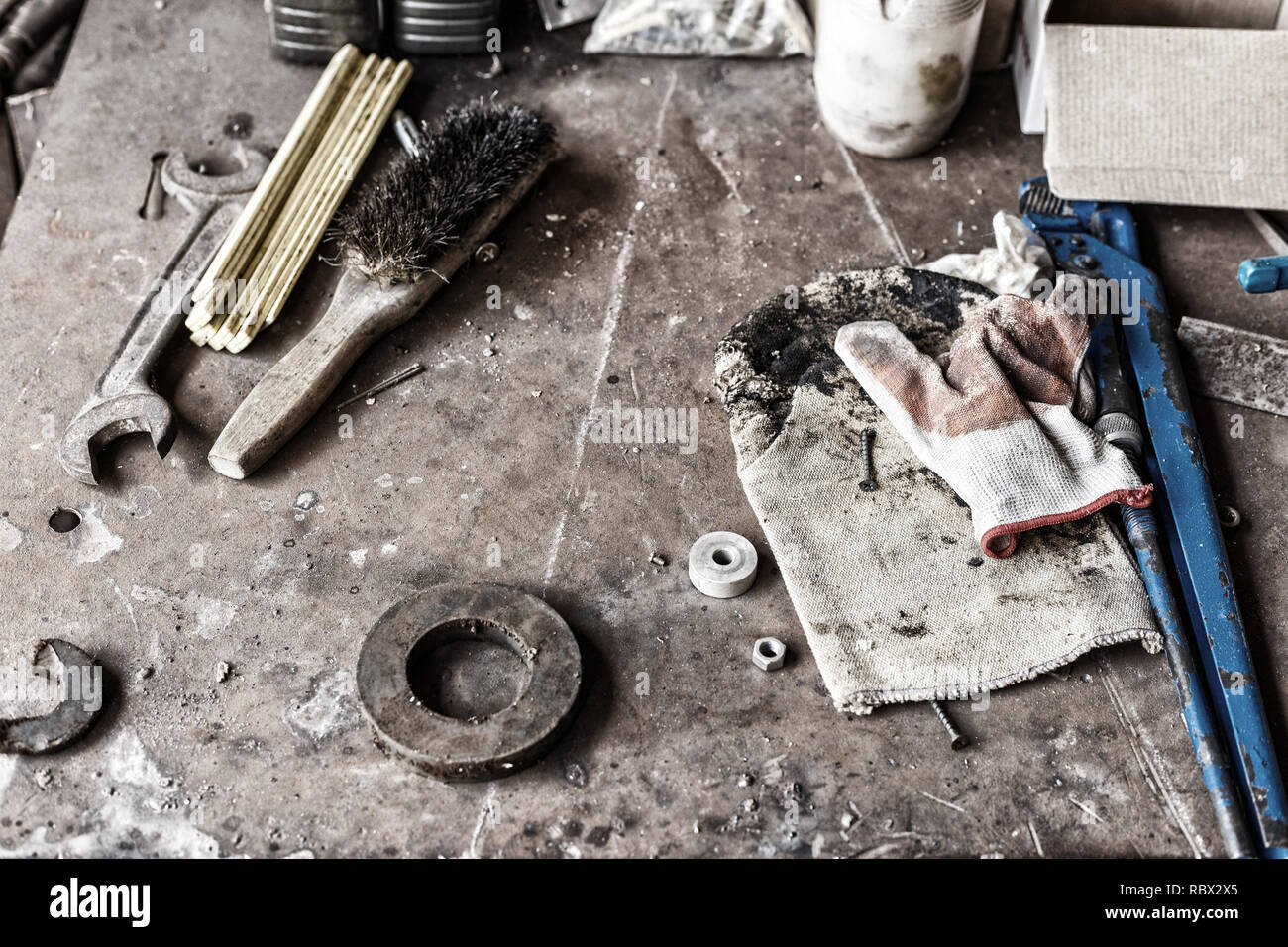 uncleared workshop with tools. on the dirty stone table scattered tools Stock Photo