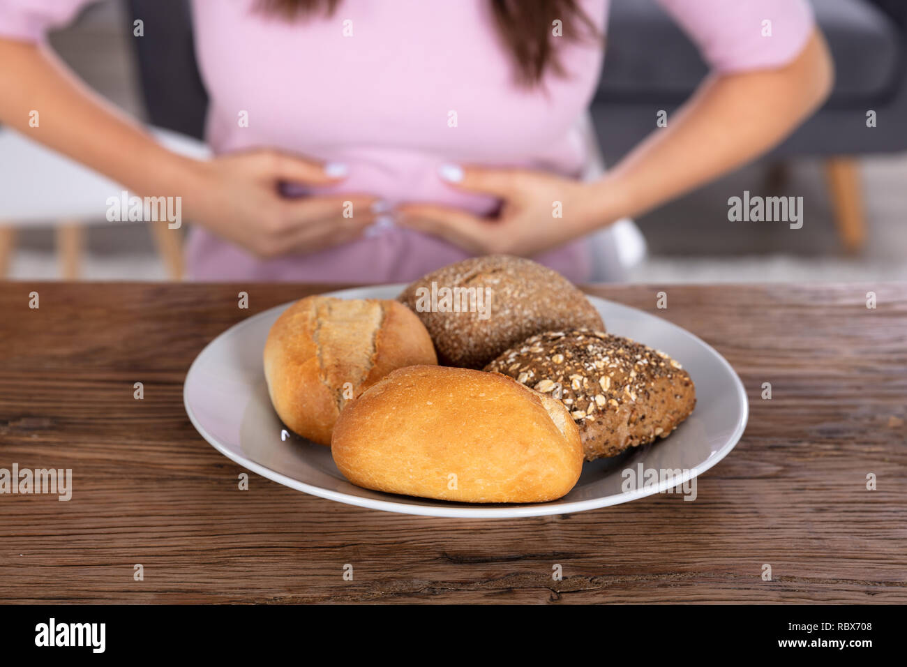 Unhealthy Food On Plate In Front Of Person Having Stomach Pain Stock Photo