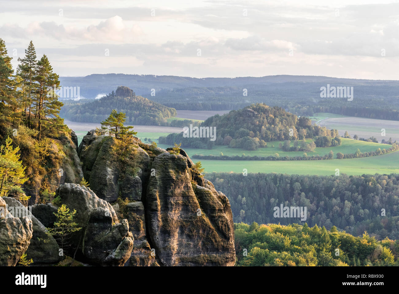 Elbe Sandstone Mountains - view to the mountains "Zirkelstein" and "Kaiserkrone", in the foreground a rock formation with trees in autumn color, light Stock Photo