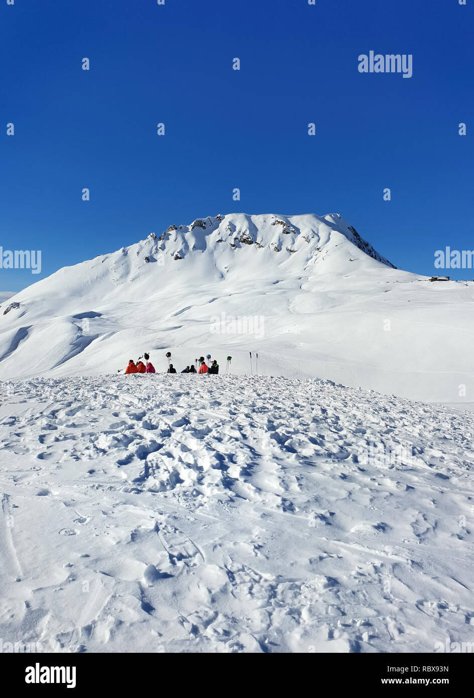 beautiful view on alpine french snowy mountain with people sitting far off Stock Photo