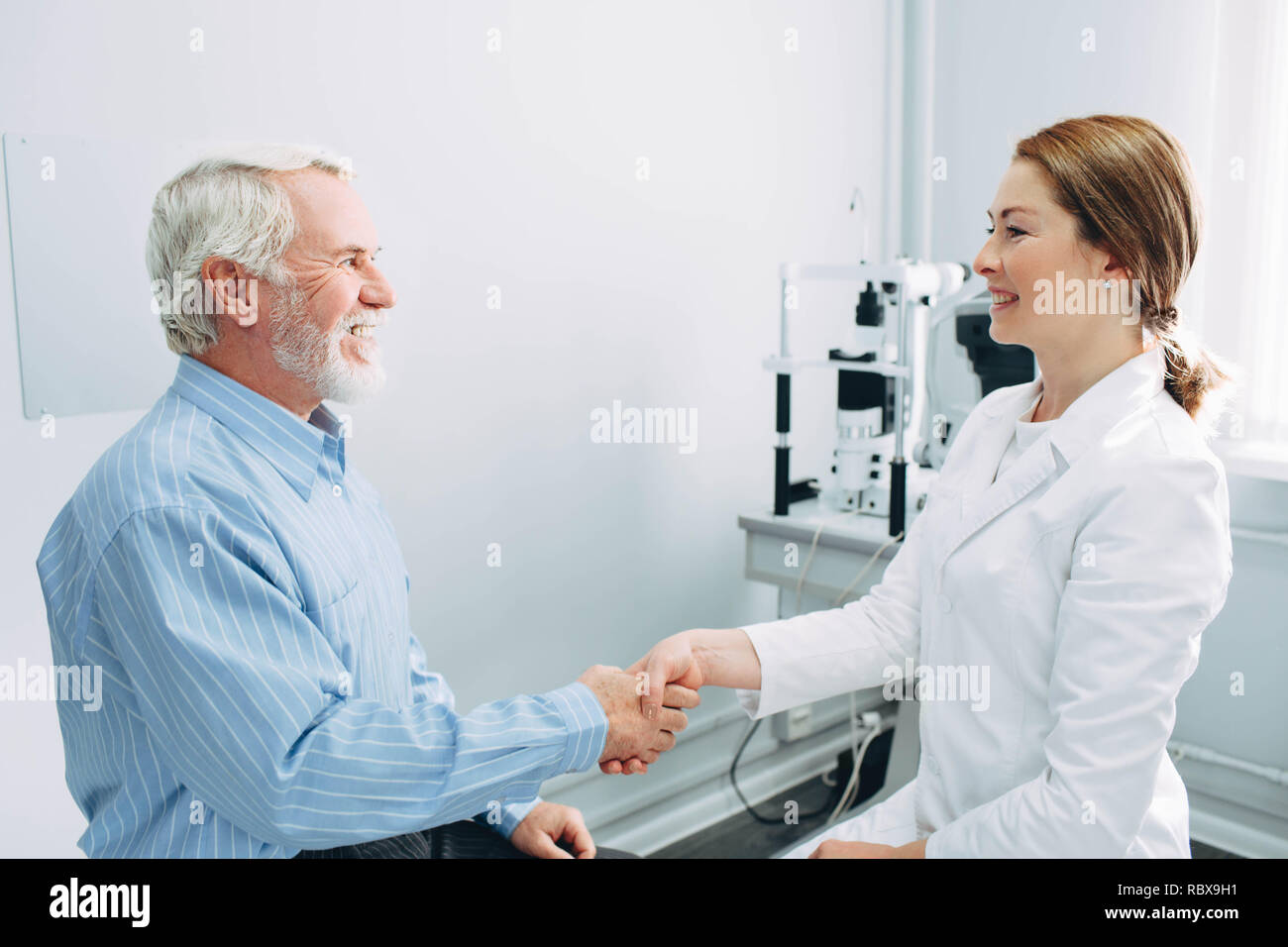 Handshake with patient,senior man at optometrist office. doctor, consultation and reception of od patient Stock Photo