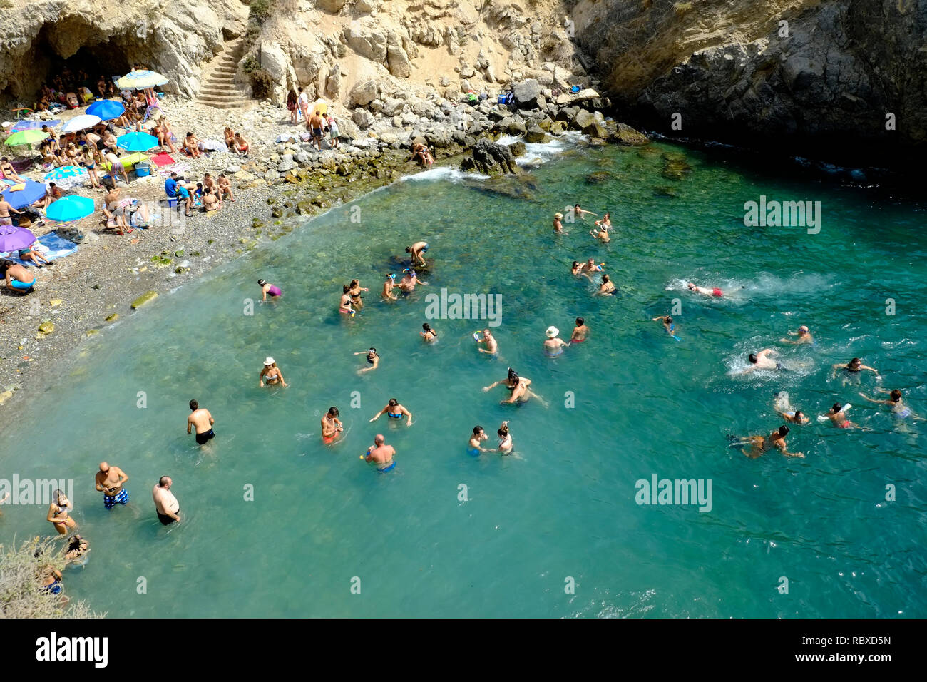 View of a crowded beach cove at the weekend in August on the island of Tabarca, Alicante. Spain Stock Photo