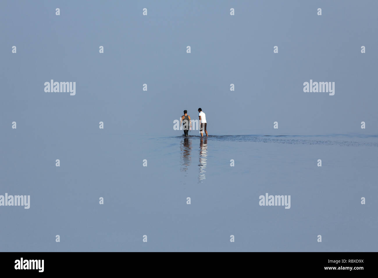 Two man walking on salt flat of Urmia Lake, West Azerbaijan province, Iran Stock Photo