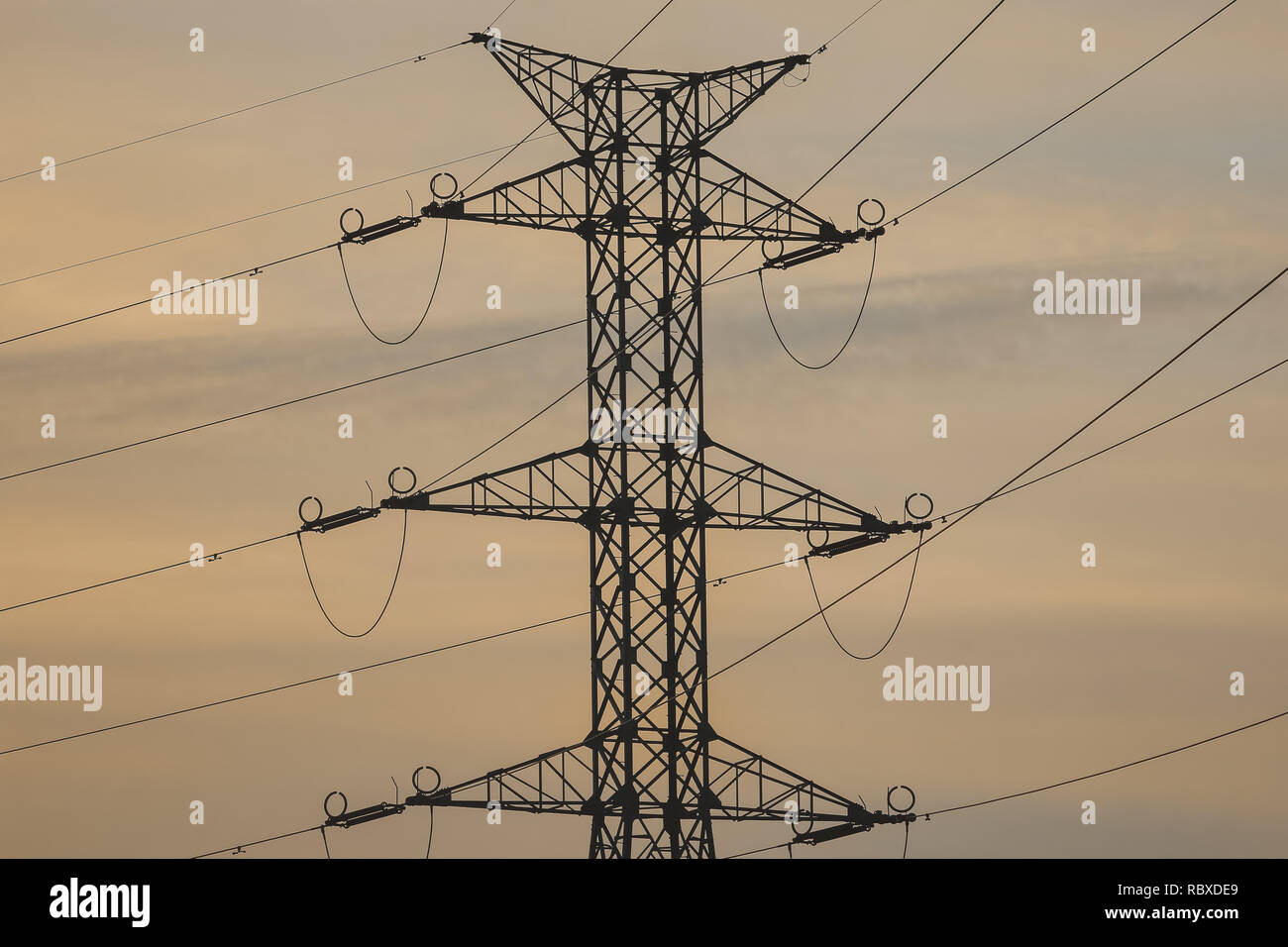 High-voltage power transmission towers in sunset sky background Stock ...