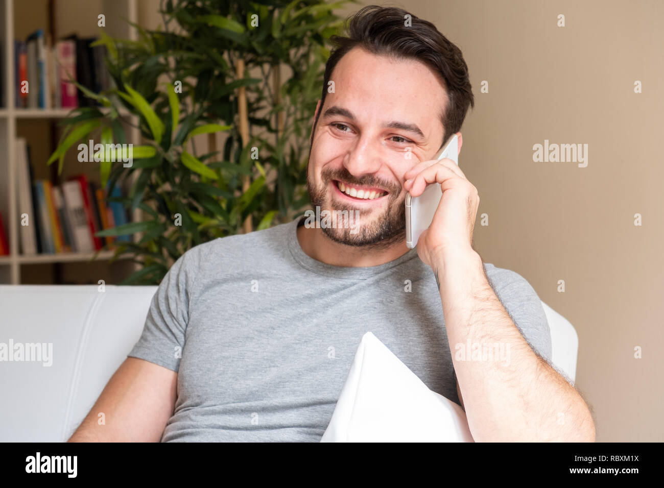 Cheerful man making a phone call at home Stock Photo - Alamy