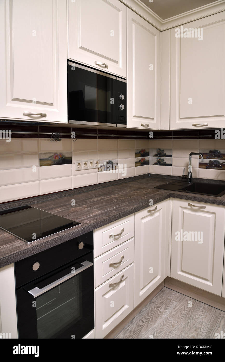 Beige kitchen with oven and a microwave Stock Photo