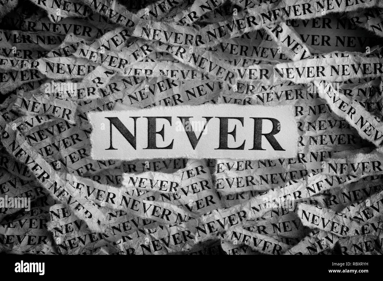Never. Torn pieces of paper with the words Never. Concept image. Black and White. Close up. Stock Photo