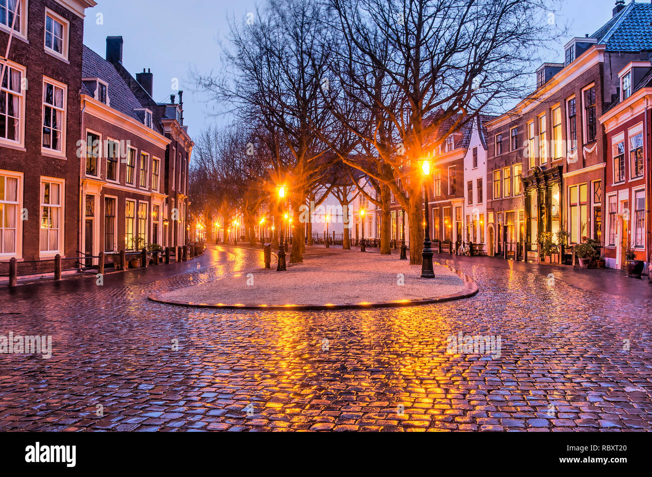 Leiden, The Netherlands, January 7, 2019: The light of od-fashioned street lanterns reflects on the cobblestone pavement of former canal Hooglandse Ke Stock Photo