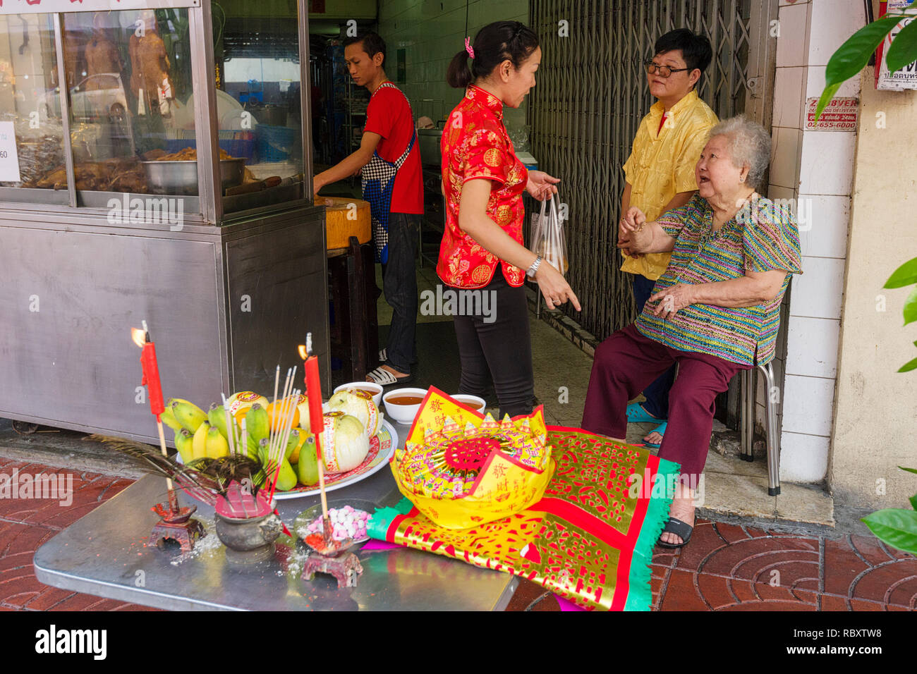 offerings arranged on the sidewalks by the owner of a restaurant during Chinese New Year Celebrations in Bangkok, Thailand Stock Photo