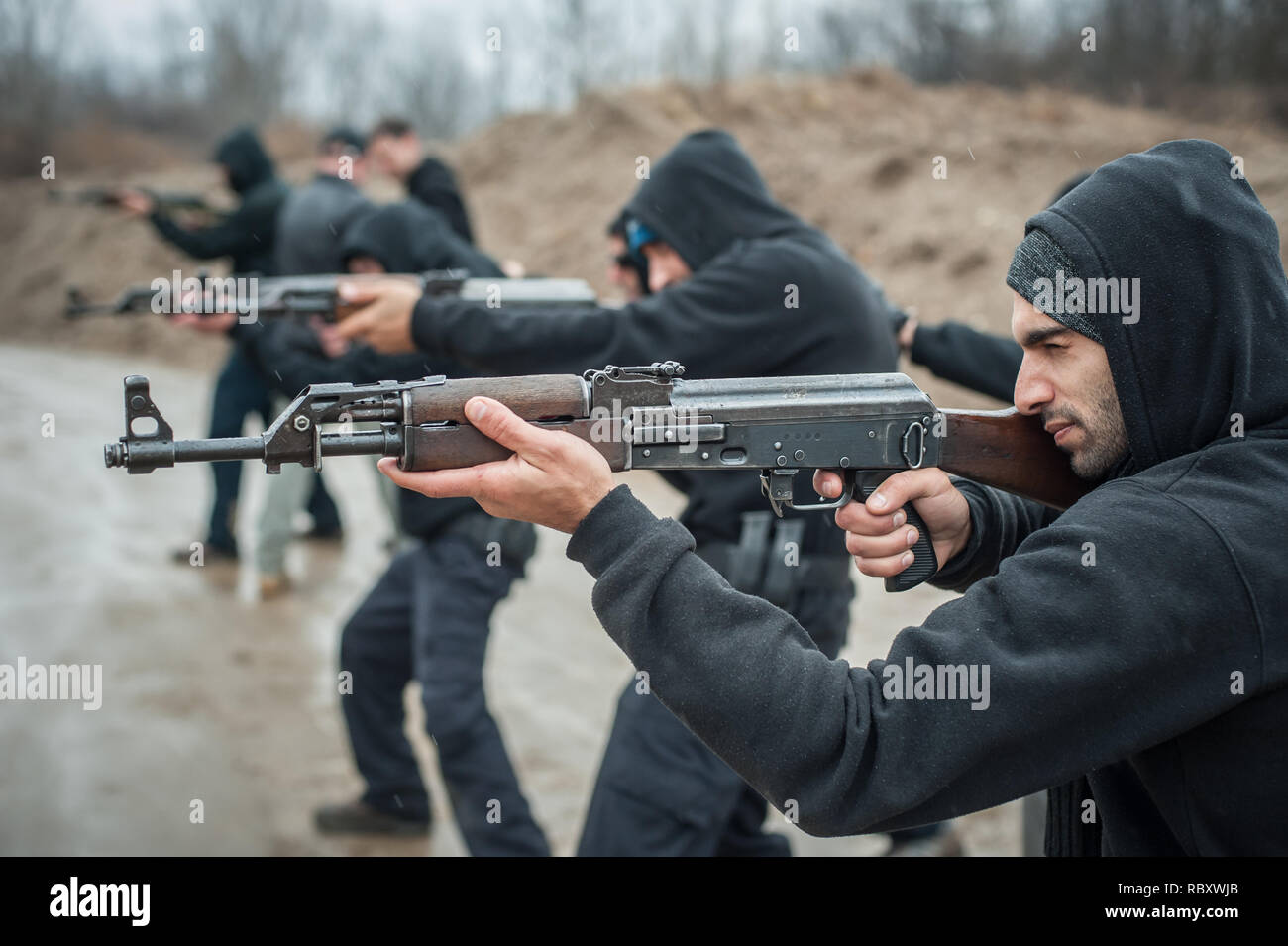 Large team, group of civilian people have action training with rifle machine gun on outdoor