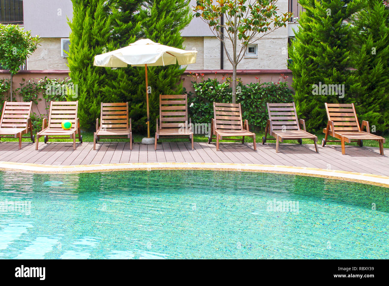 Swimming pool with lounges and parasol Stock Photo Alamy
