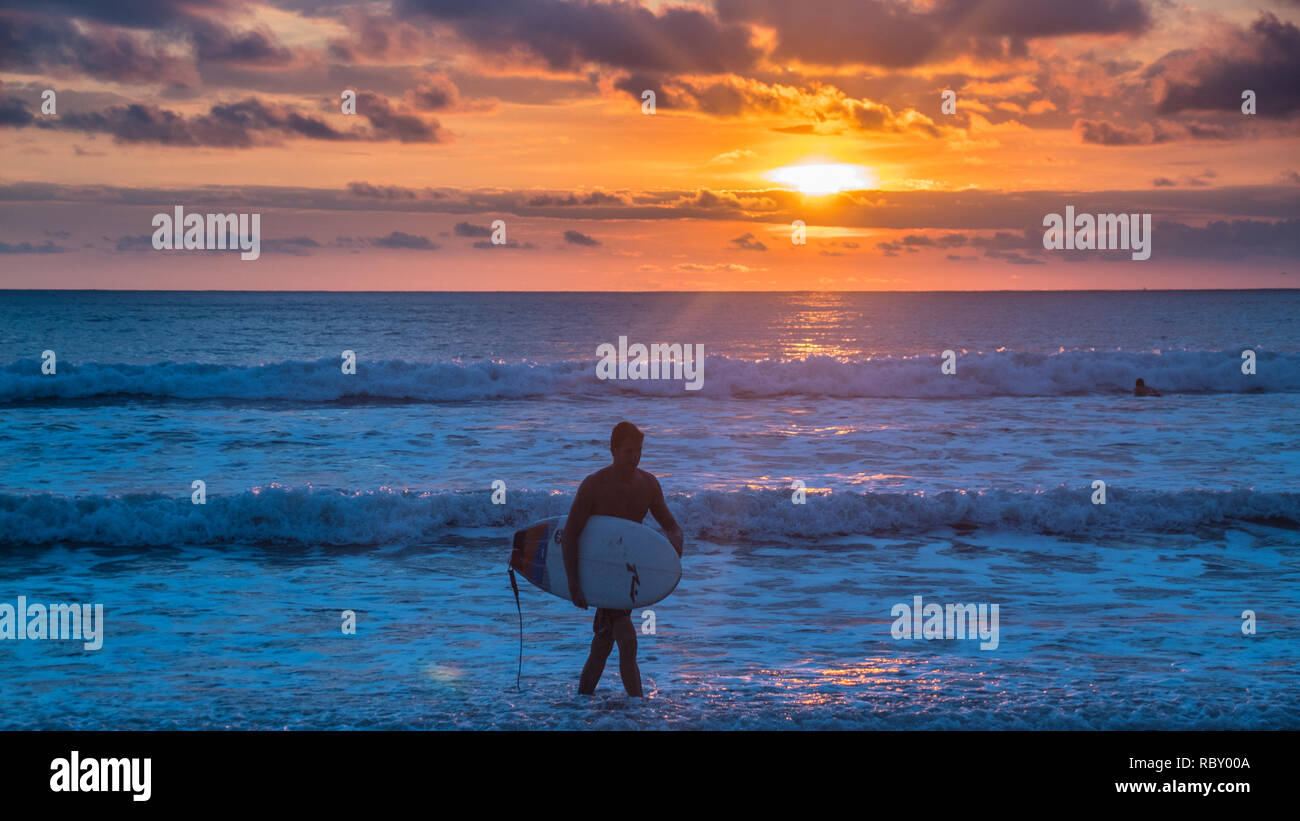 A photo of a silhouette of a male surfer returning from the ocean on ...