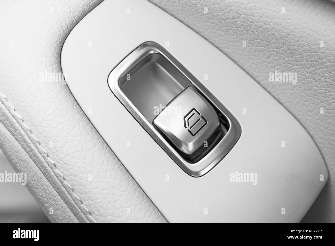 Car white leather interior details of door handle with windows controls
