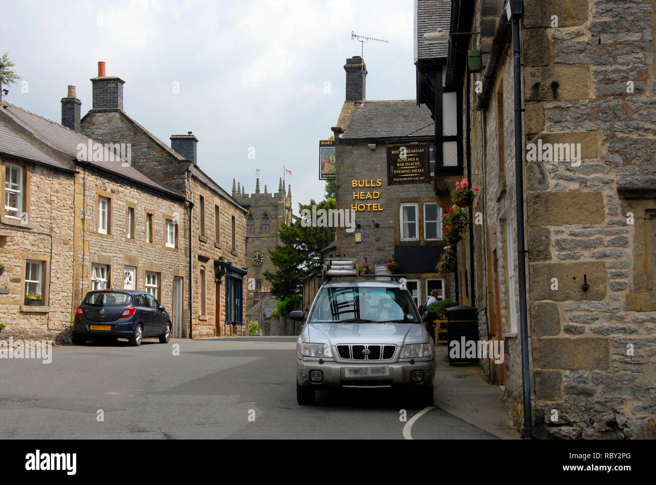 Fountain Square, Youlgreave, Derbyshire, with Bull's Head Hotel and village church beyond. Stock Photo