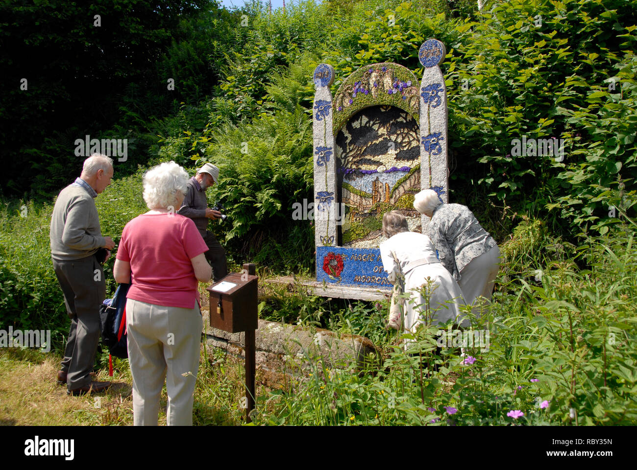 Five elderly people looking an example of well dressing, Youlgreave, Derbyshire, England. Stock Photo
