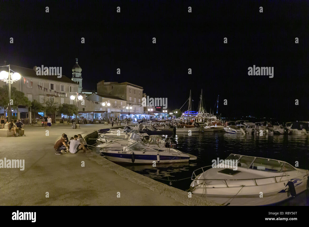 Boats and yachts in the harbour in front of the Old historic town of Krk with the tower of the Cathedral of the Assumption of the Blessed Virgin Mary  Stock Photo