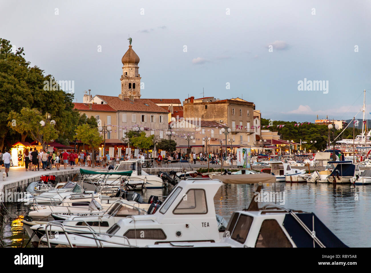 Boats and yachts in the harbour in front of the Old historic Town of Krk. The Cathedral of the Assumption of the Blessed Virgin Mary in the background. Stock Photo
