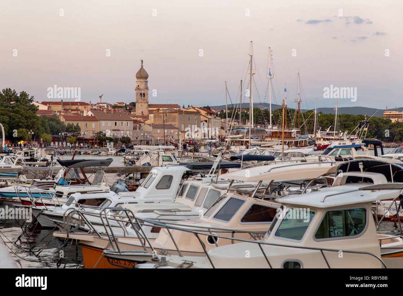 Tower of  The Cathedral of the Assumption of the Blessed Virgin Mary and boats and yachts in the harbour in front of the Old historic Town of Krk. Stock Photo