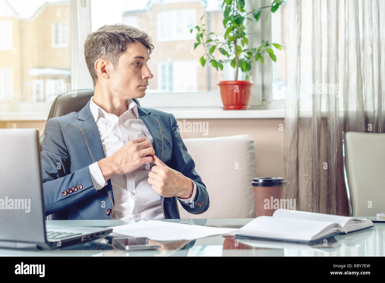 Businessman official sitting in the workplace in the office hides a bribe unnoticed in his pocket. The concept of corruption and bribery Stock Photo