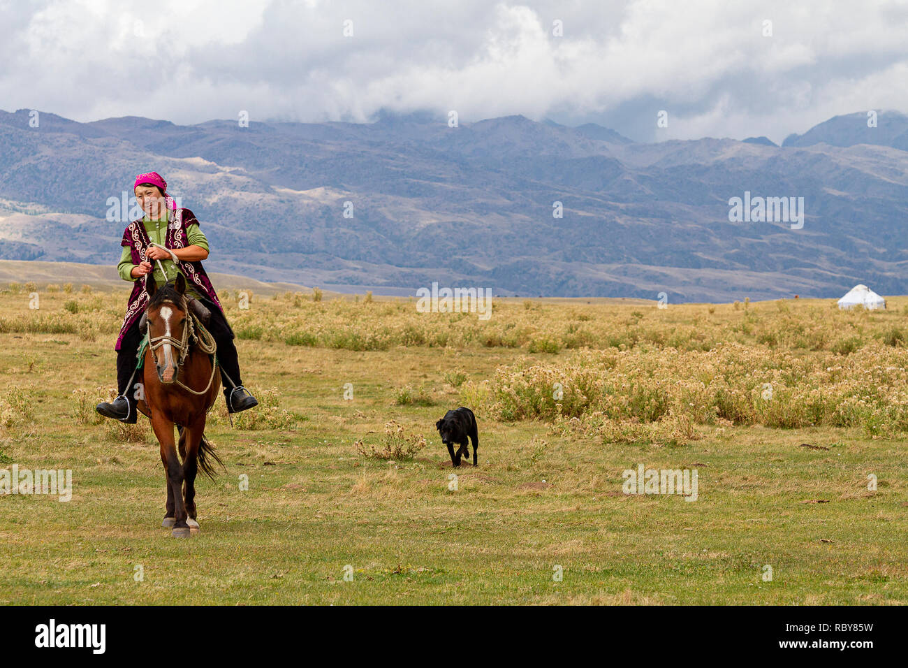 Nomadic woman riding her horse in the plateau, Kazakhstan. Stock Photo