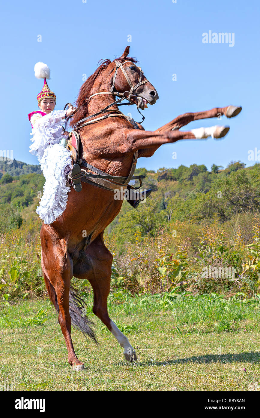 Kazakh woman in national costumes rearing up her horse, in Almaty, Kazakhstan. Stock Photo