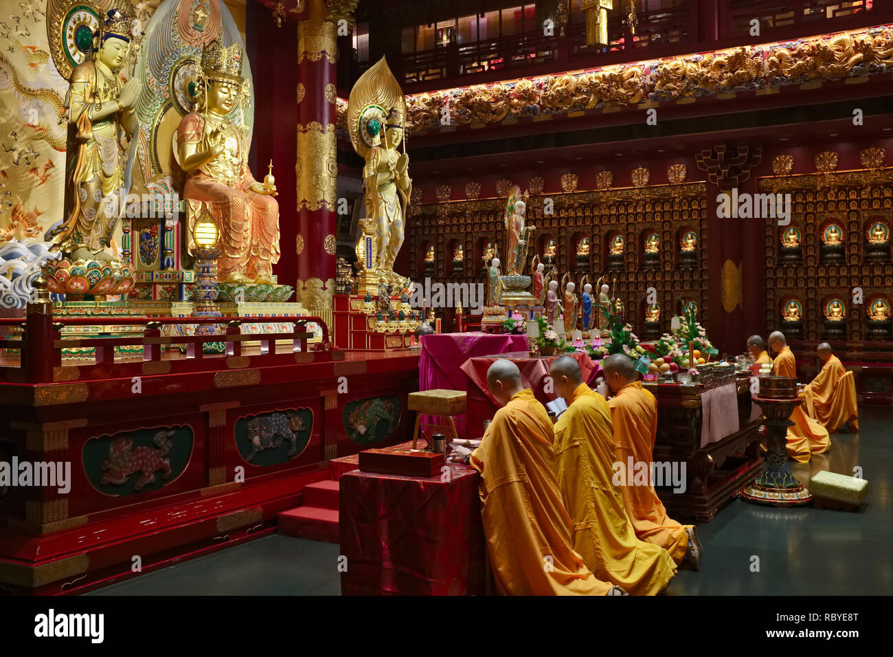 Buddhist monks praying in the prayer hall of the Buddha Tooth Temple