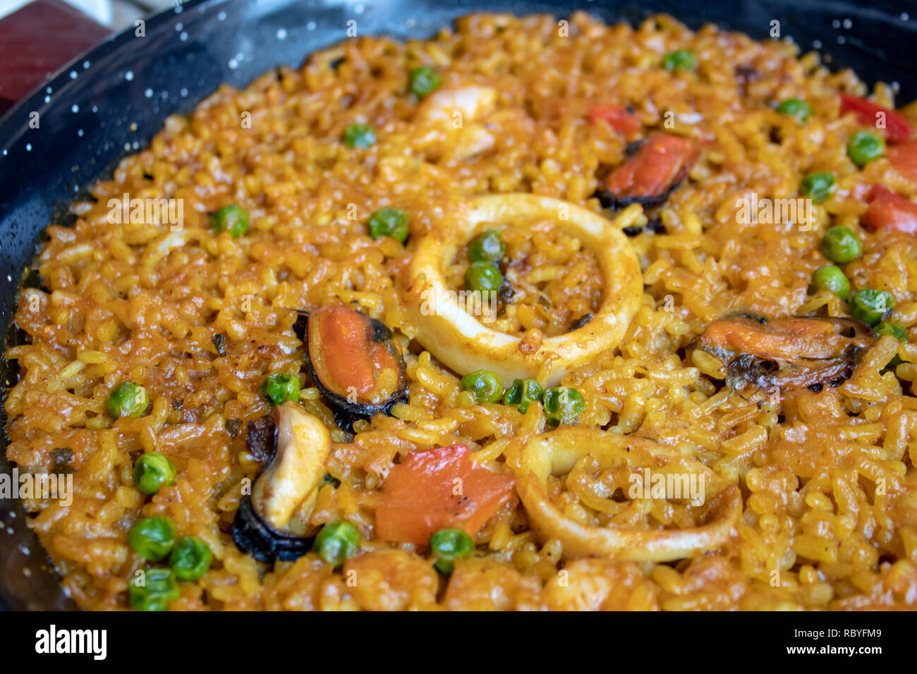 Fresh Spanish paella with rice and seafood in frying pan closeup Stock Photo
