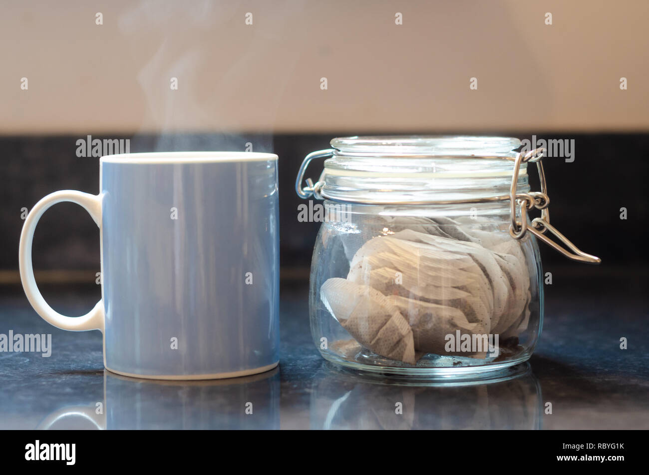 A blue mug and jar of tea bags on a kitchen worktop. Stock Photo