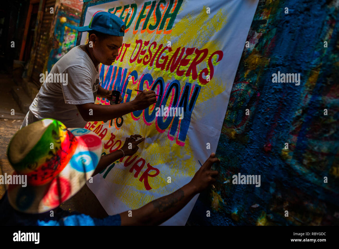 A Colombian sign painter paints letters on a hand-painted promotional ...