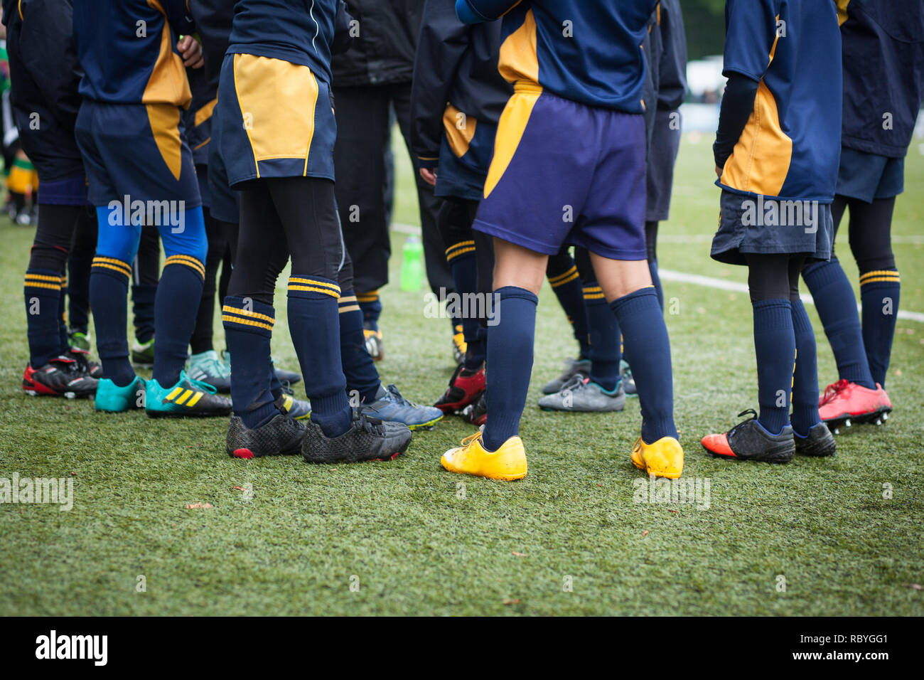 Legs of Rugby playing boys in a huddle Stock Photo