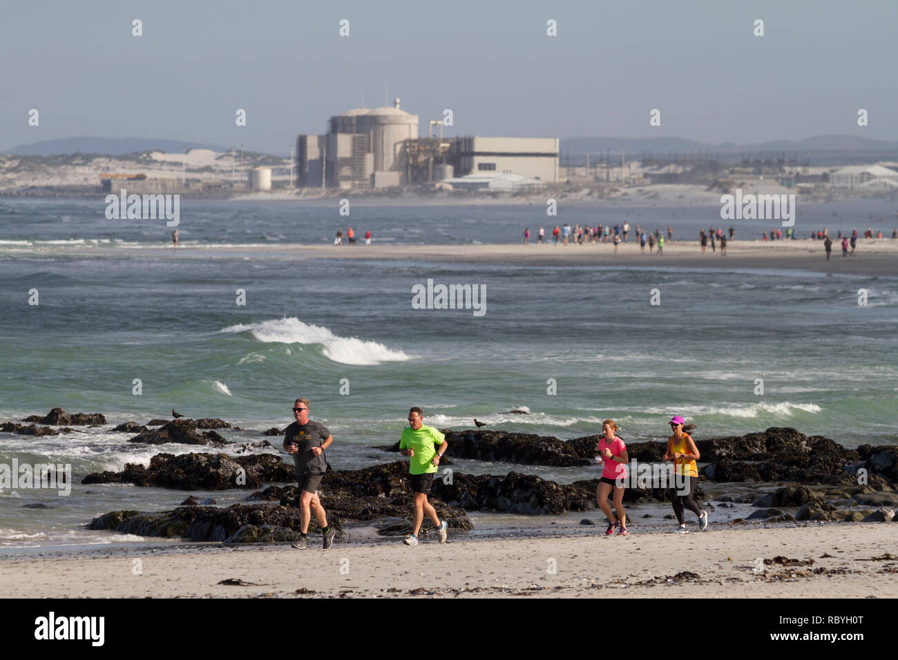 Parkrun jog on the beach at Melkbosstrand with Koeberg Power Station in the background. Parkrun is a global movement of Saturday 5km runs outside. Stock Photo