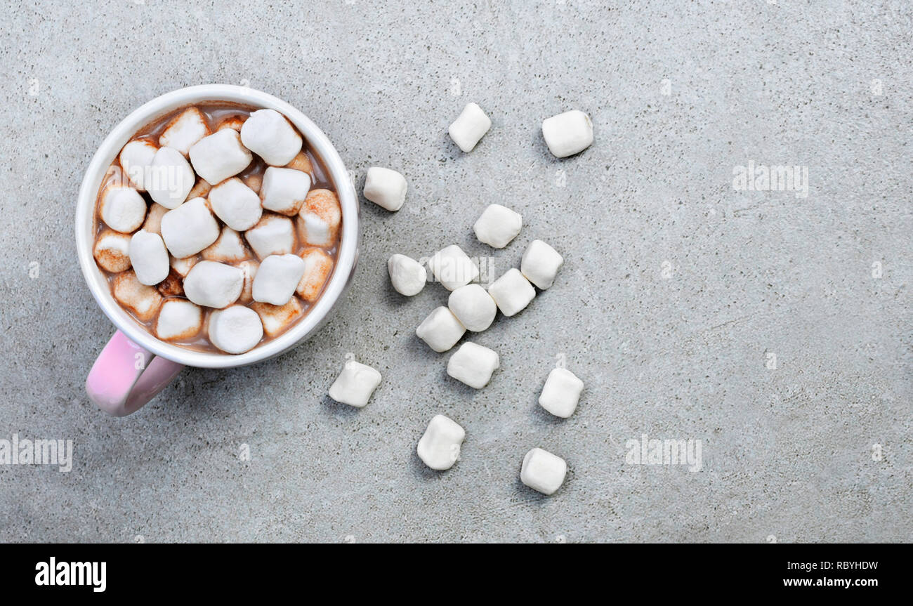 Hot chocolate or cocoa drink in a cup or mug. Top view of hot chocolate with marshmallows on a stone background. Stock Photo