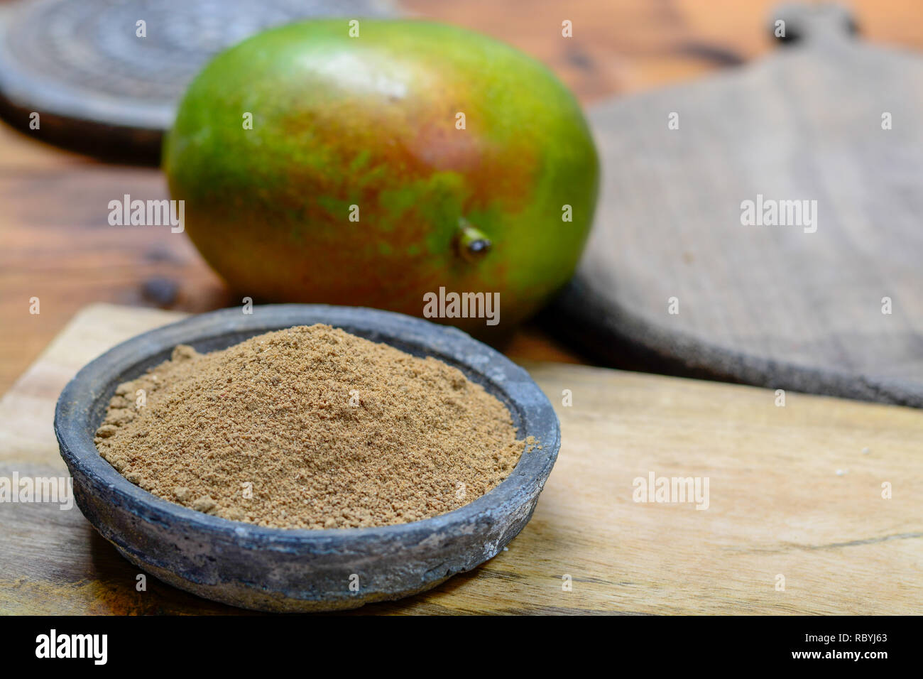 Amchoor or aamchur, mango powder, fruity spice powder made from dried unripe green mangoes in India, used to flavor foods close-up Stock Photo