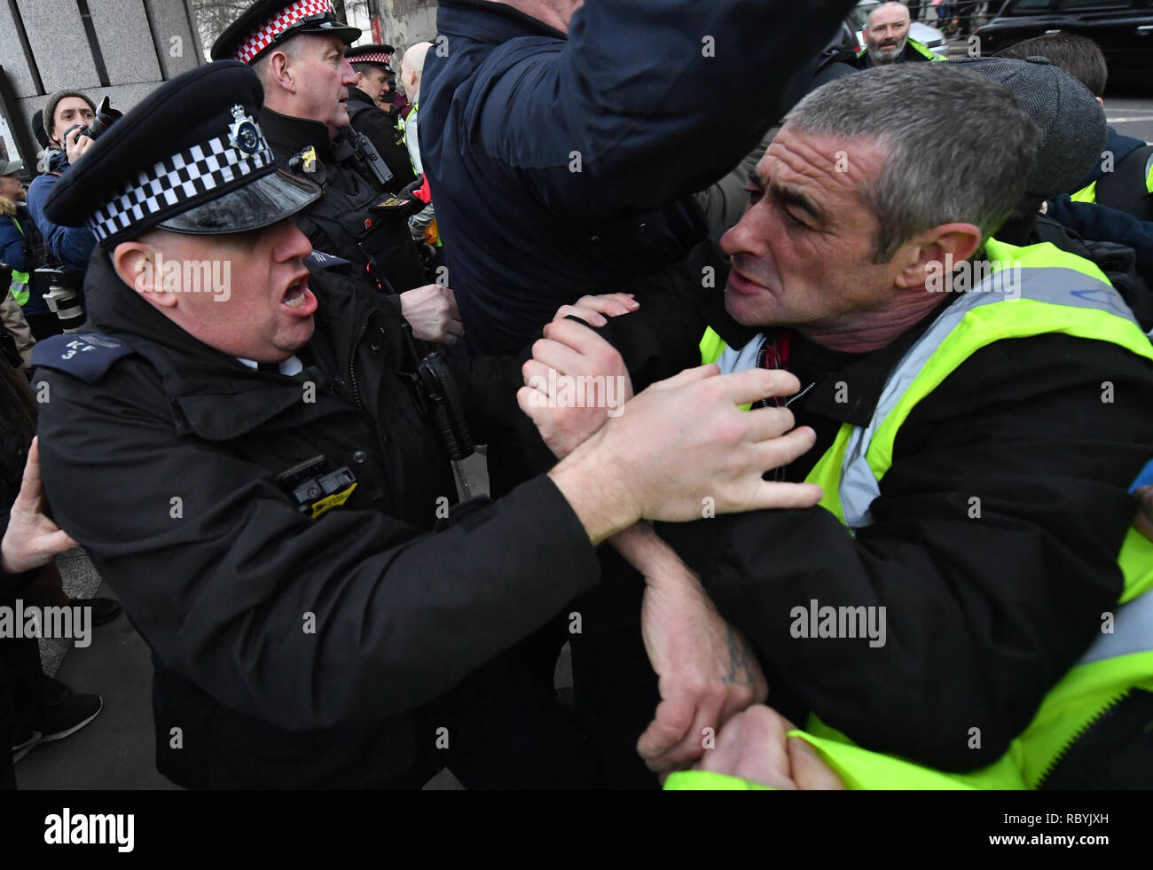 Police officers tussle with Pro-Brexit demonstrators as they attempt to get into Trafalgar Square, London, where a rally organised by the People's Assembly Against Austerity are gathered. Stock Photo