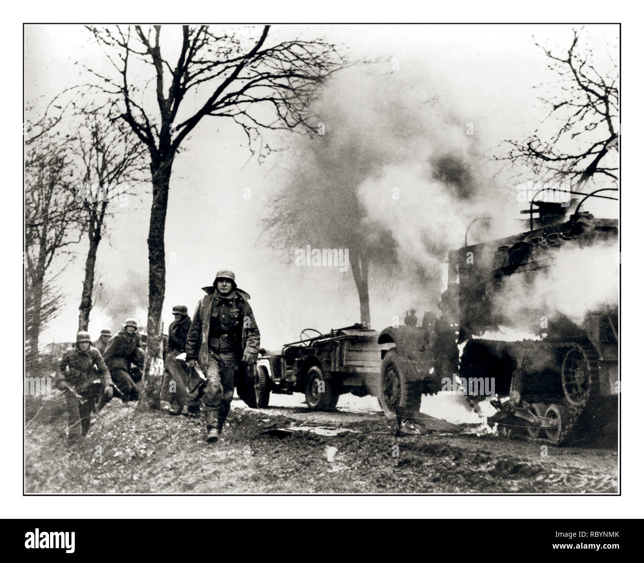 WW2 ‘Battle of the Bulge’ Soldiers from the 2nd SS Panzer Division ‘Das Reich’ are walking past the American convoy destroyed in the area of the Belgian city of Manhay. “The Battle of the Bulge 1944. Hitler’s Last Hope”.Belgium Date: December 24, 1944 Stock Photo