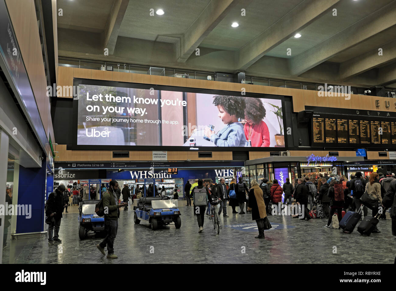 Uber taxi electronic advert billboard advertising the Uber app for mobile phones inside Euston Station concourse in London England UK  KATHY DEWITT Stock Photo