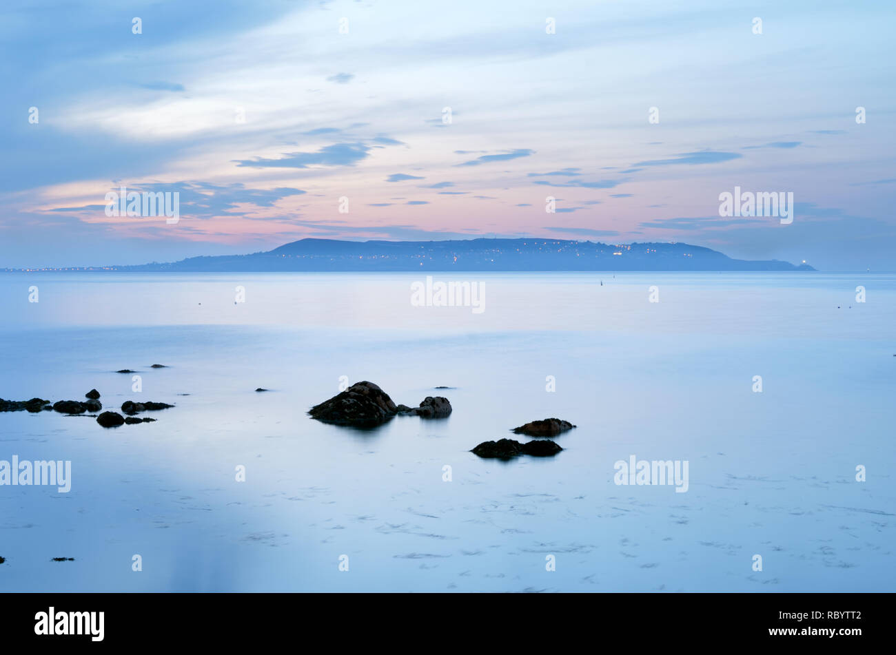 Flat calm sea,windless day,peninsula of howth,suburb of county dublin as seen across dublin bay,ireland. Stock Photo