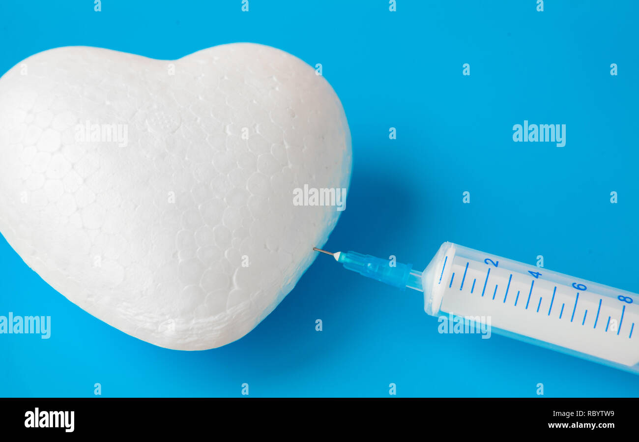 Hand holding plastic Syringe medical injection of red heart. medical ...