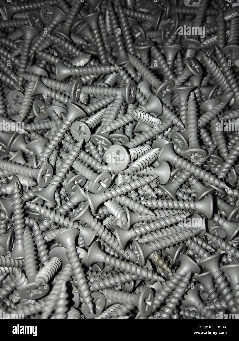 Screws flat lay vertical orientation with gradient light. Industrial background with many metal parts for construction Stock Photo