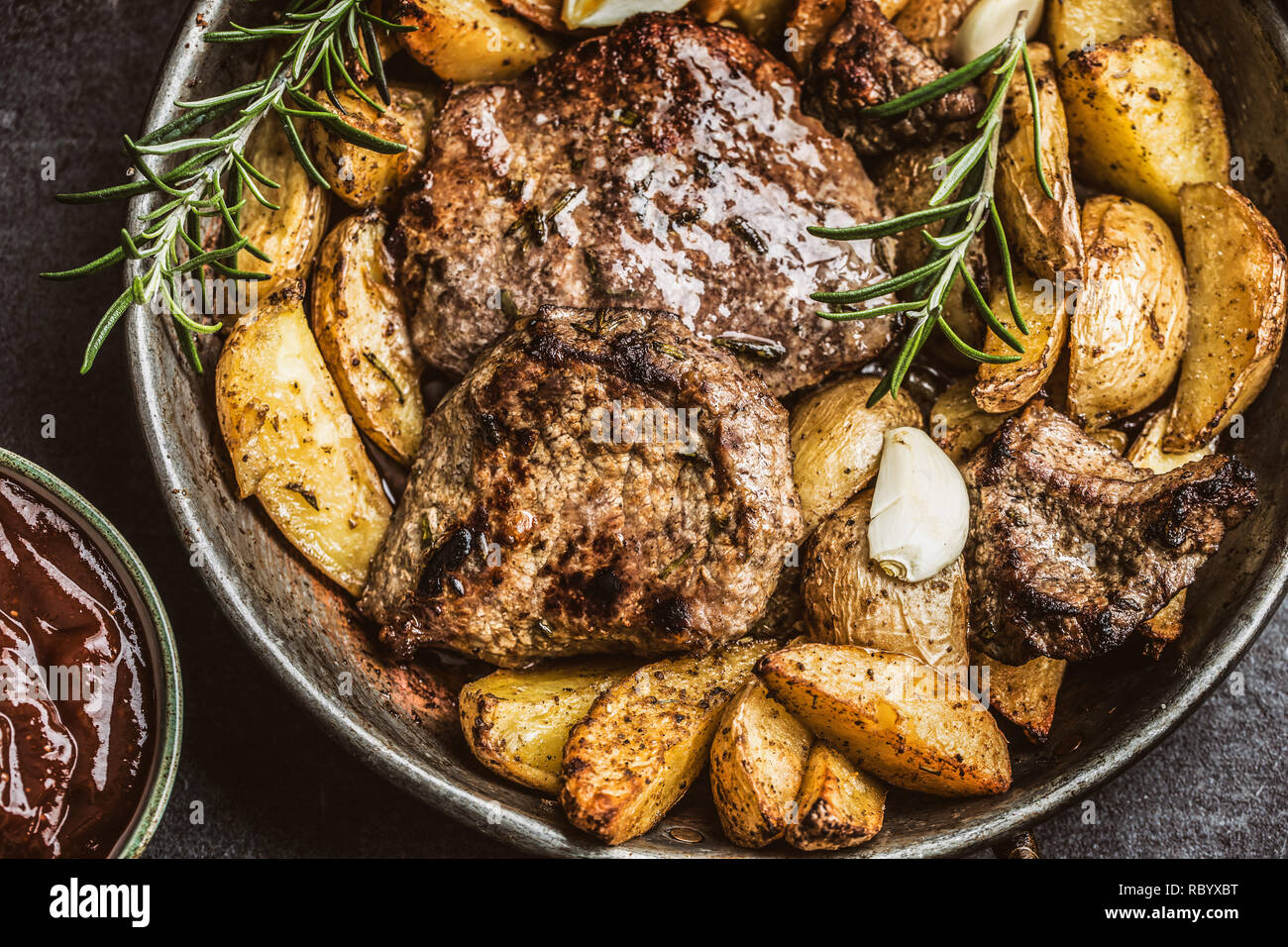 Beef grilled steaks with barbecue sauce roasted potatoes and rosemary