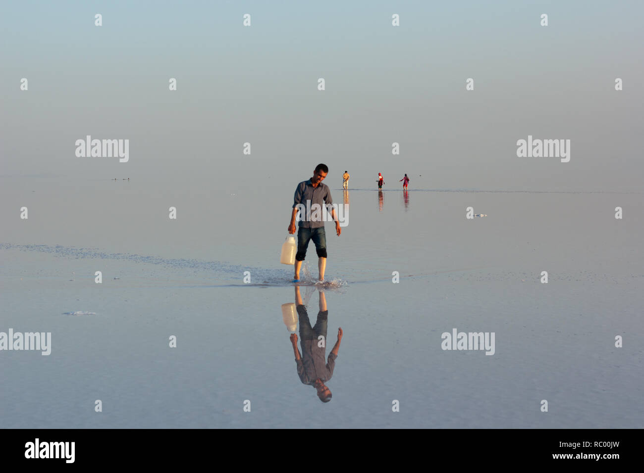A man walking alone on salt flat of Urmia Lake, West Azerbaijan province, Iran Stock Photo