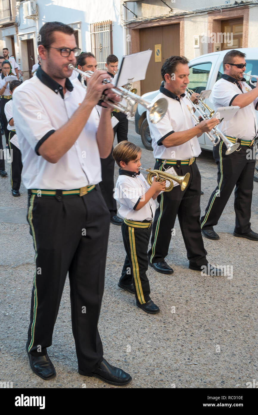 Marching band with small boy on trumpet during fiesta time parading in the streets of Carcabuey, Andalusia. Spain Stock Photo