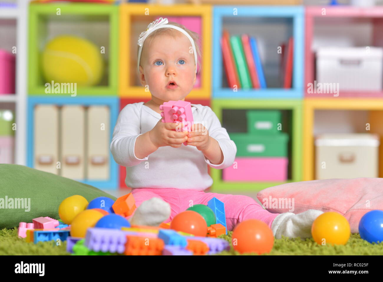 Portrait of little child playing with colorful toys Stock Photo - Alamy