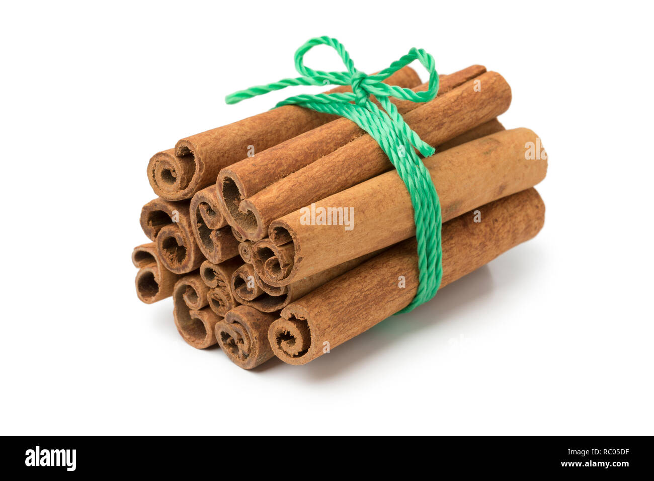 Bunch of cassia cinnamon sticks with a green cord Stock Photo