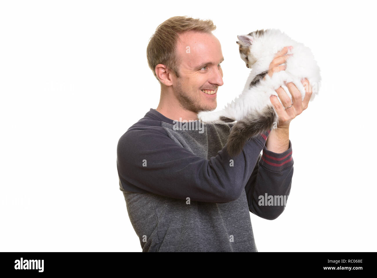 Happy handsome Caucasian man holding cute kitten Stock Photo