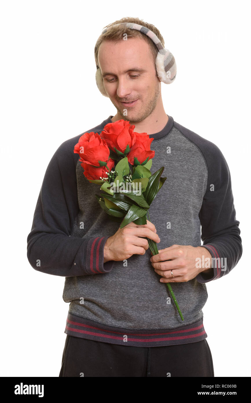 Handsome Caucasian man holding red roses ready for Valentine's d Stock Photo