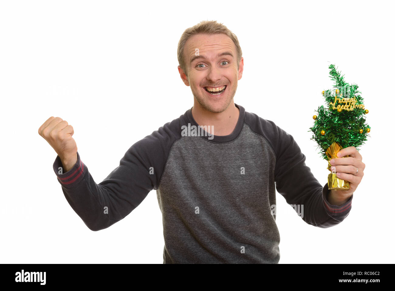 Happy Caucasian man holding Happy New Year tree looking excited Stock Photo