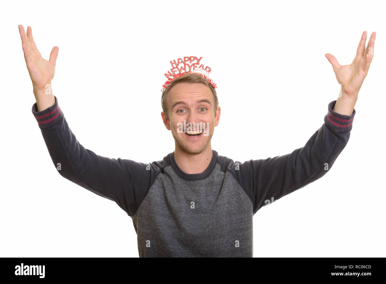 Happy Caucasian man wearing Happy New Year headband looking exci Stock Photo