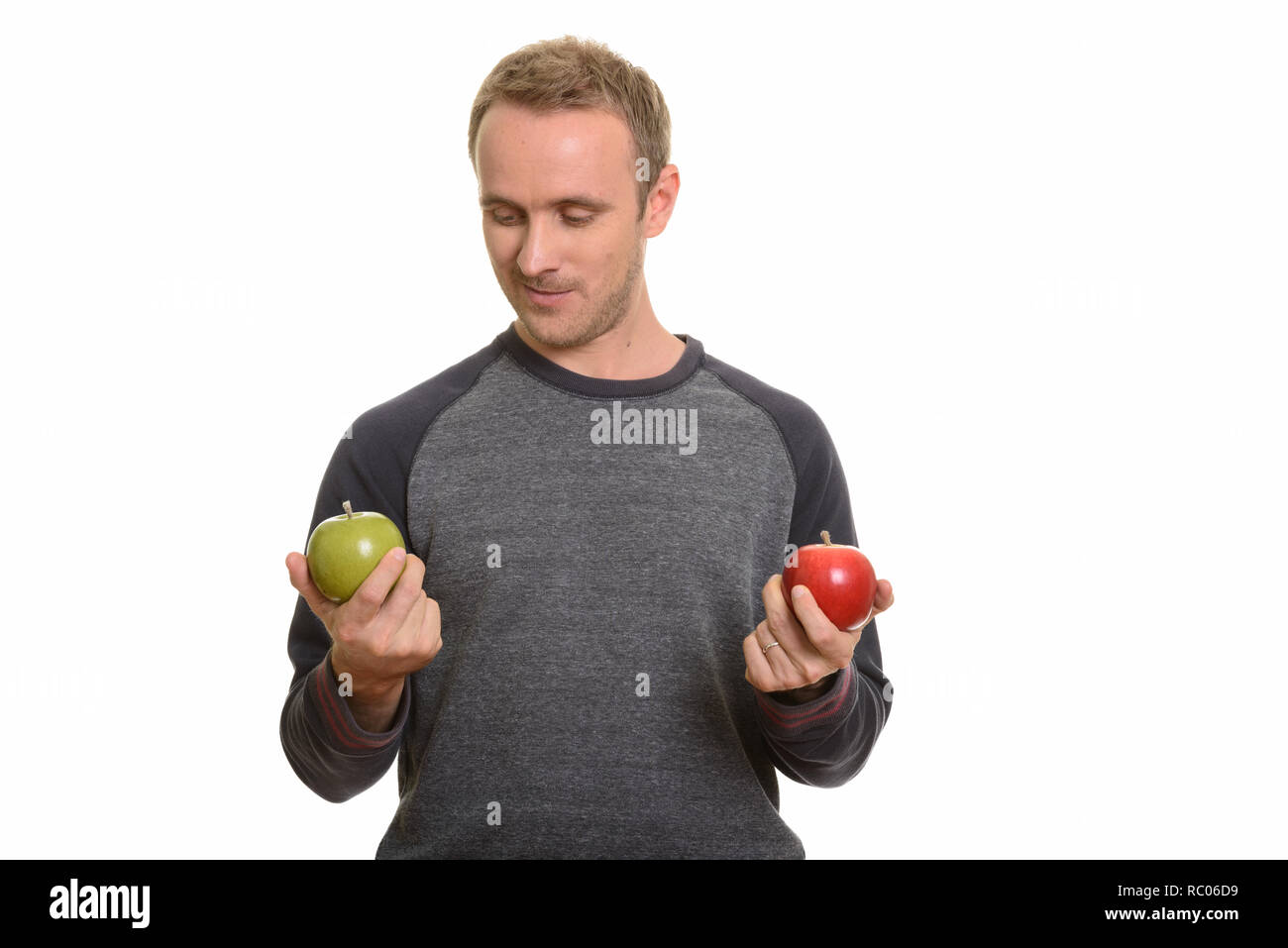 Handsome Caucasian man choosing between red and green apple Stock Photo ...